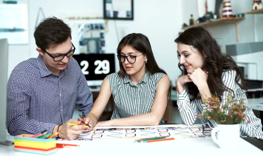 Three architects discussing a blueprint