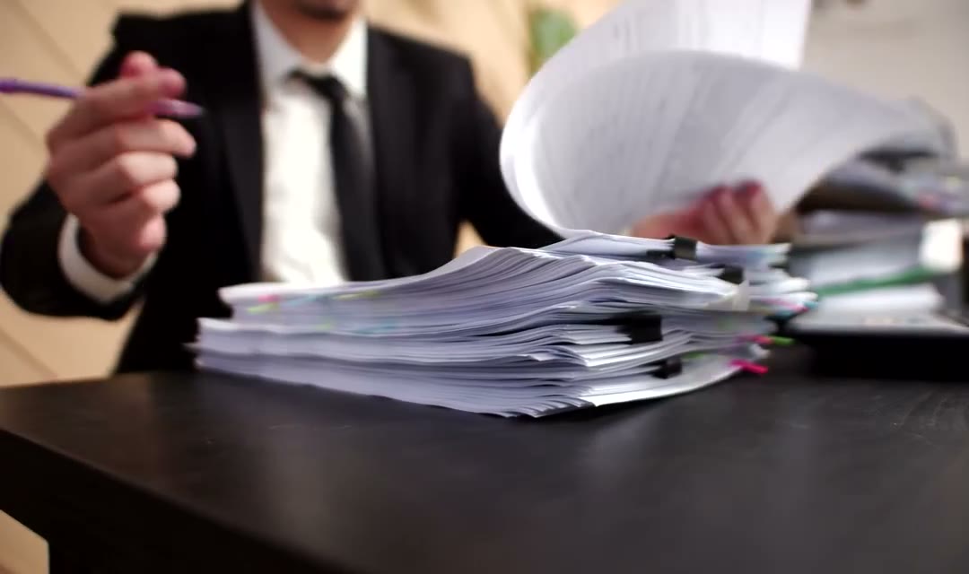 Close up of a tall stack of papers on a desk