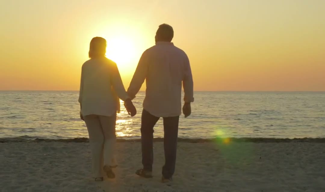 Senior couple walking at sunset