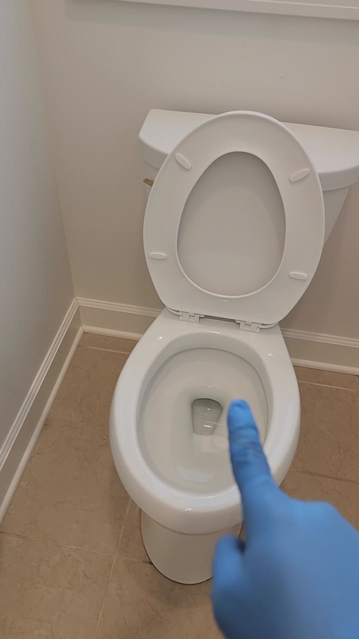 A gloved hand points at a toilet and bathroom vanity while the speaker jokes, “Hey buddy, how's the weather up there?” The 70-second video is long enough to cut