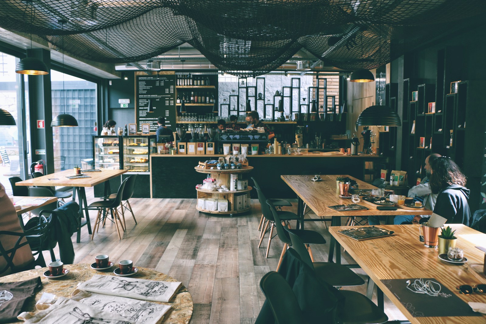 A neighborhood cafe with wooden tables and a long counter.