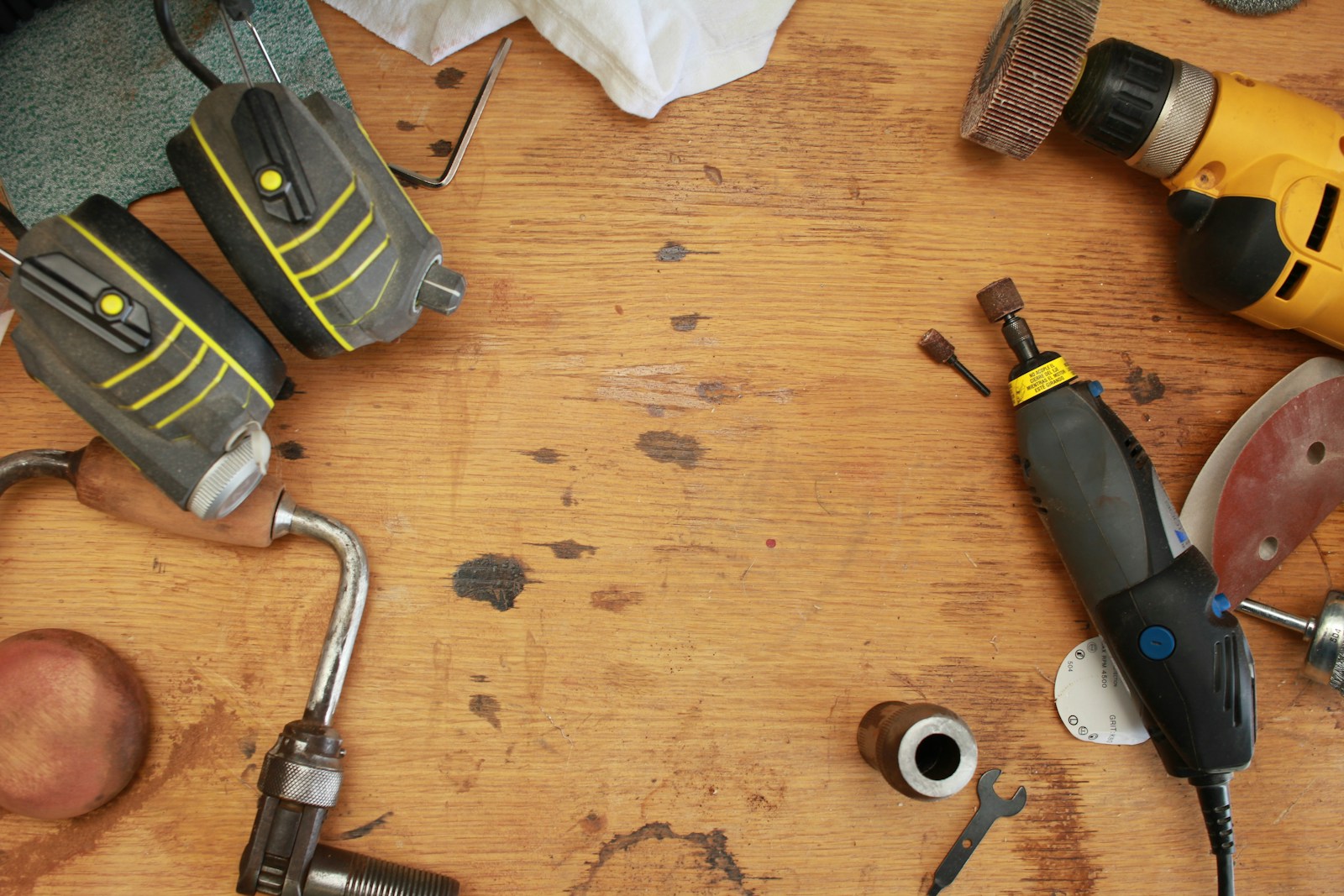 Drills, pliers and other tools arranged around an open wooden work surface.