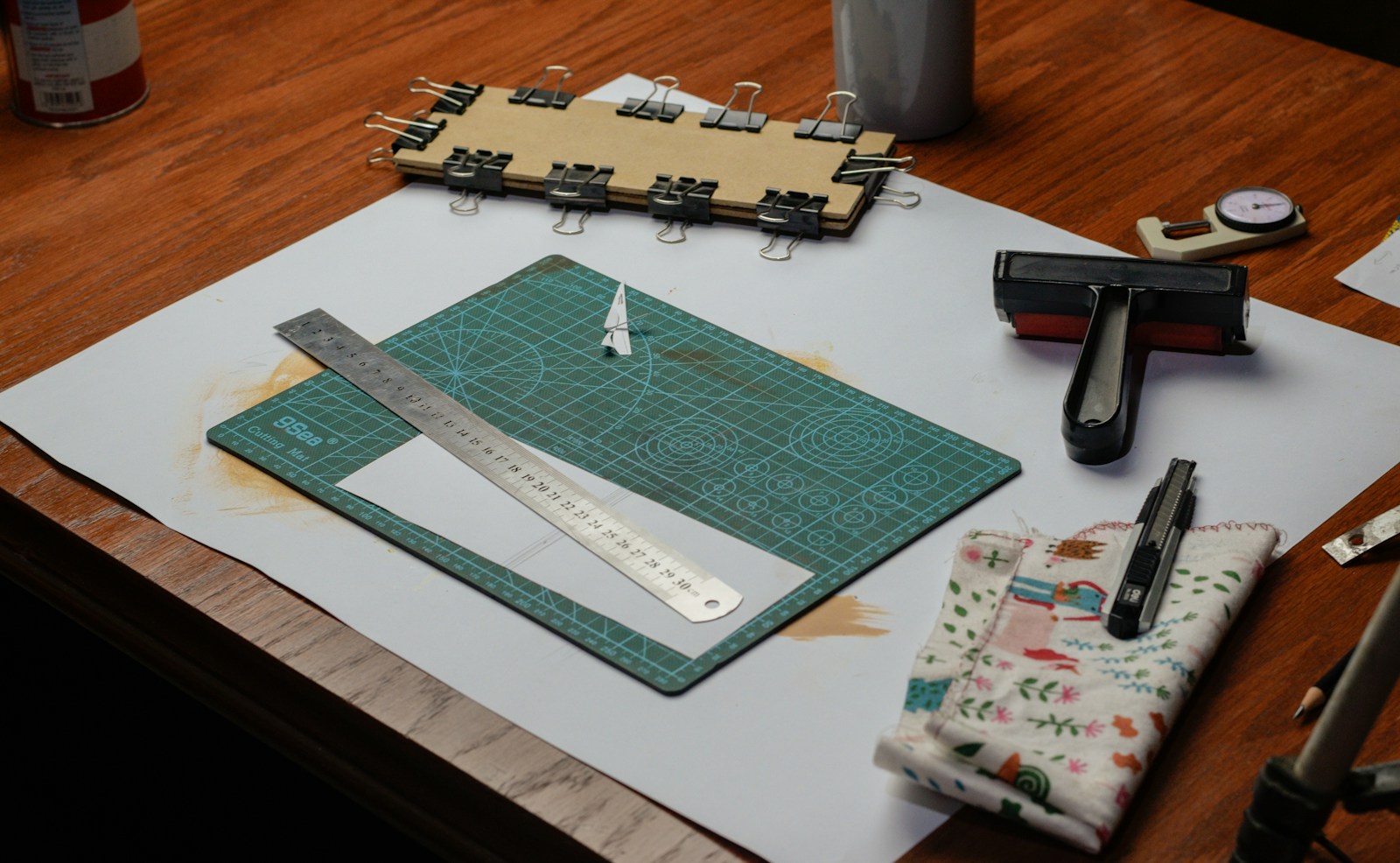 A ruler, cutting mat and leatherworking tools on a tidy work table.