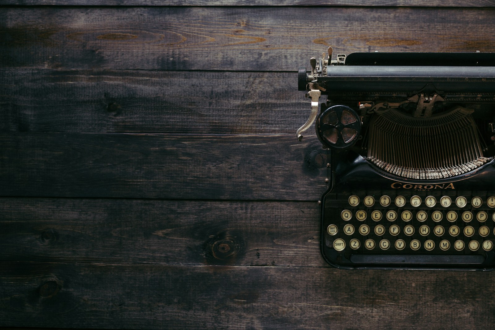 An old typewriter on a dark wooden desk.