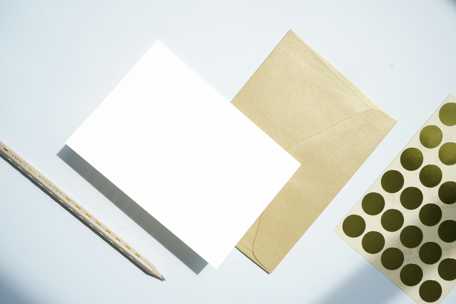 Blank note cards, a tan envelope and a pen on a light surface.