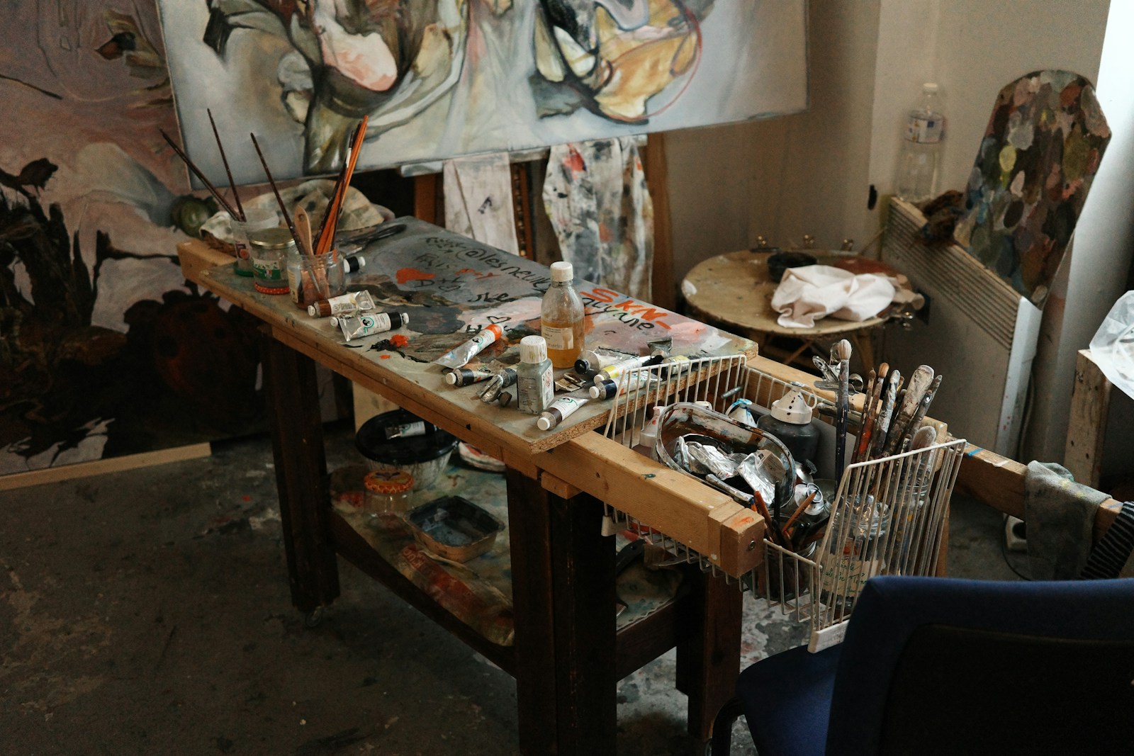 Paintbrushes, palettes and materials gathered on an artist’s studio table.
