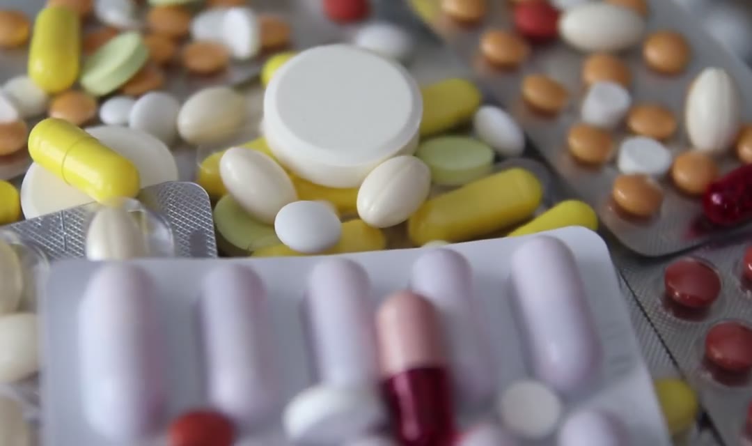 Many pills and drugs rotating, close up