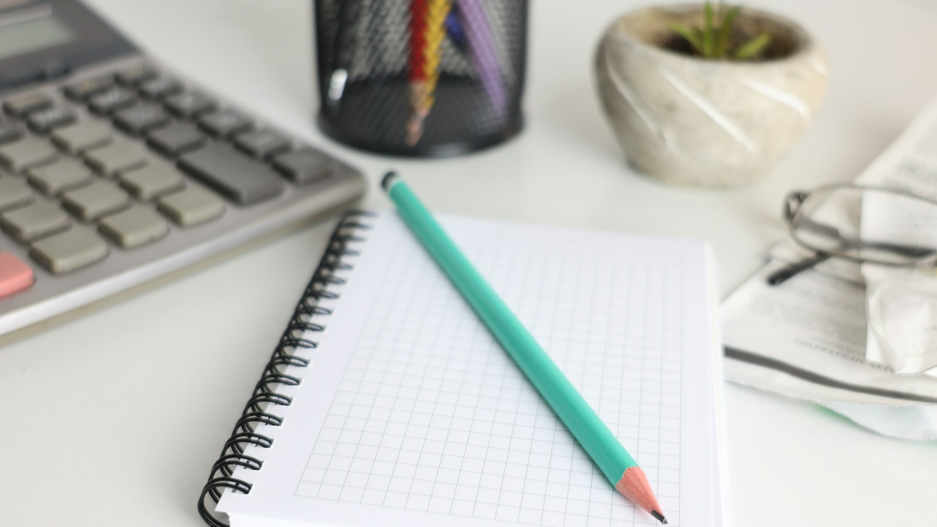 Calculator and notebook on a desk for planning a budget