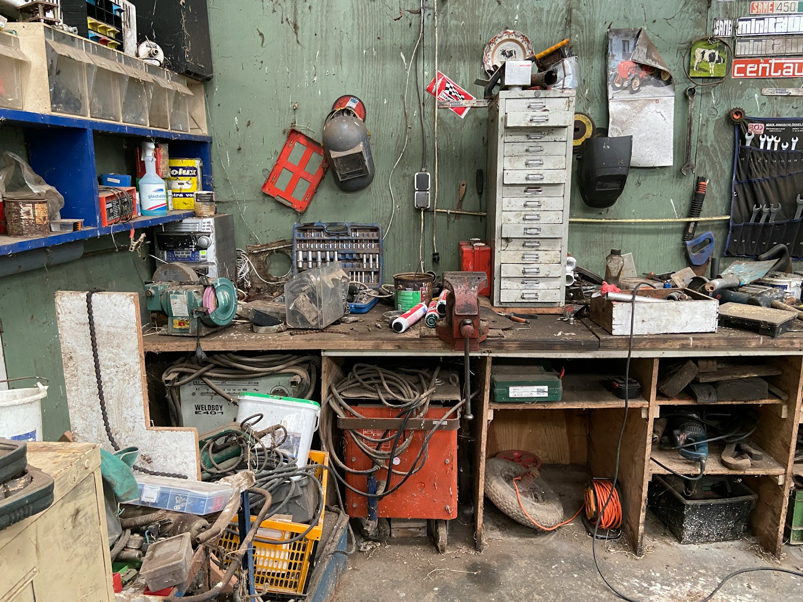 A well-used workshop wall and bench holding many different tools.