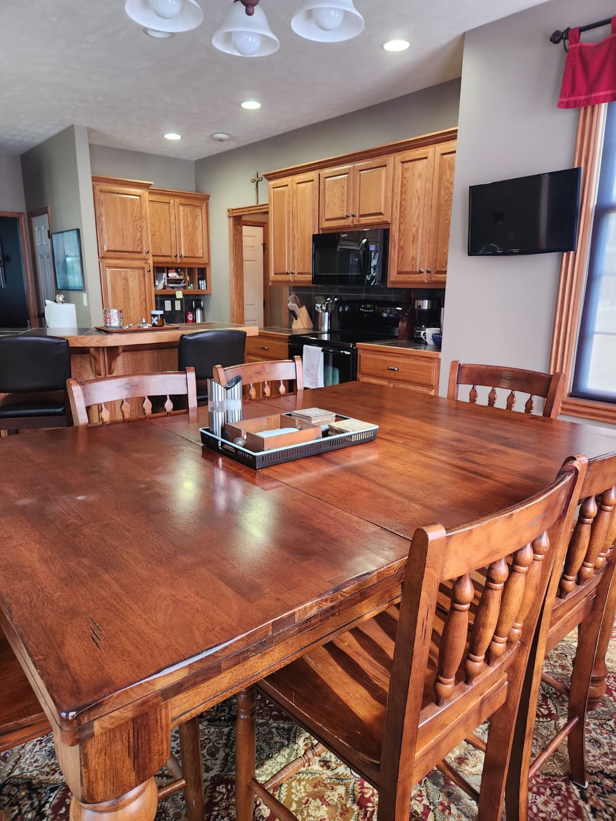 Polished wood dining table with oak kitchen cabinets behind it in a Lincoln home