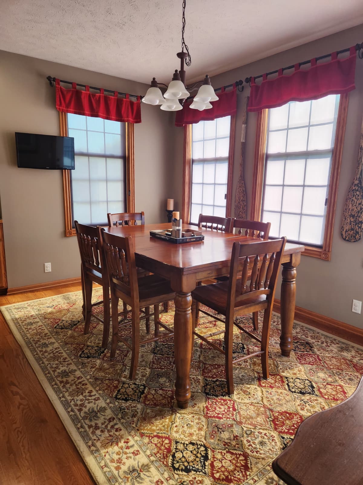 Dining table and chairs beside three windows after Breeze Cleaning finished the job