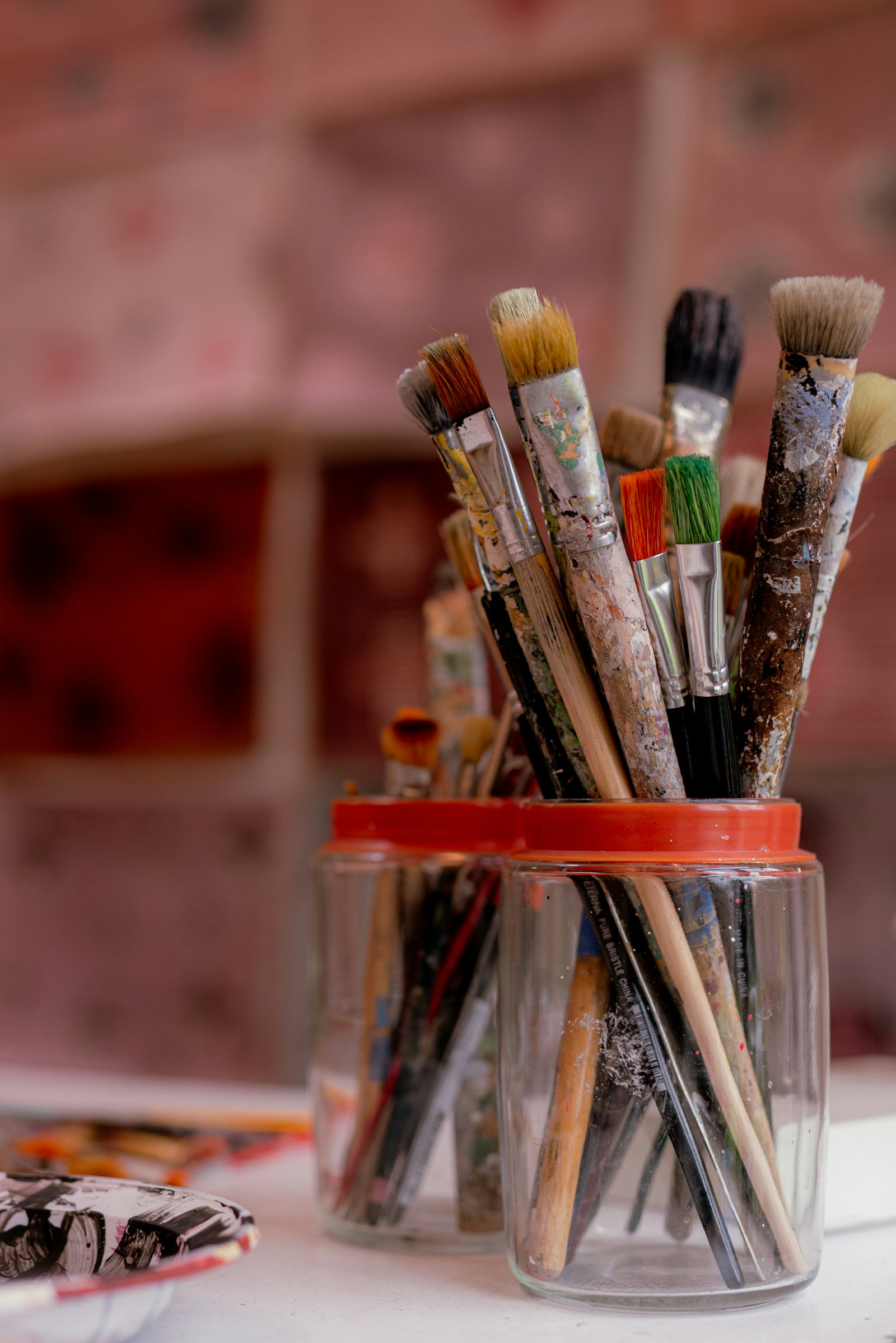 Paintbrushes of different sizes gathered in a glass jar.