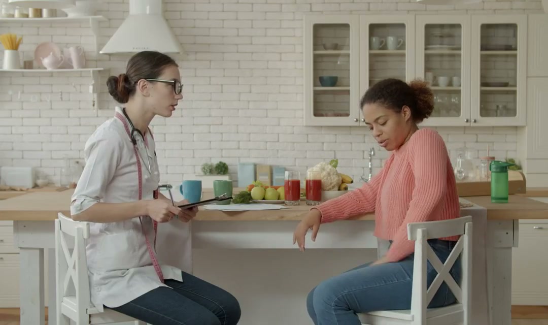 Two people sitting at a kitchen table giving each other their full attention in conversation