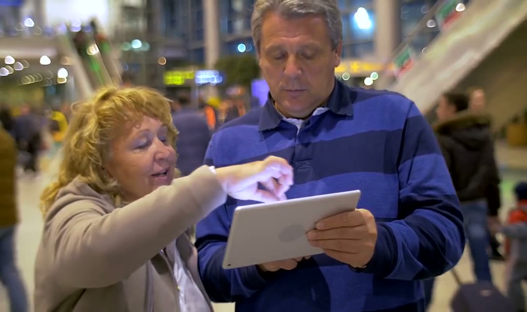 Elderly couple using a tablet while out in town