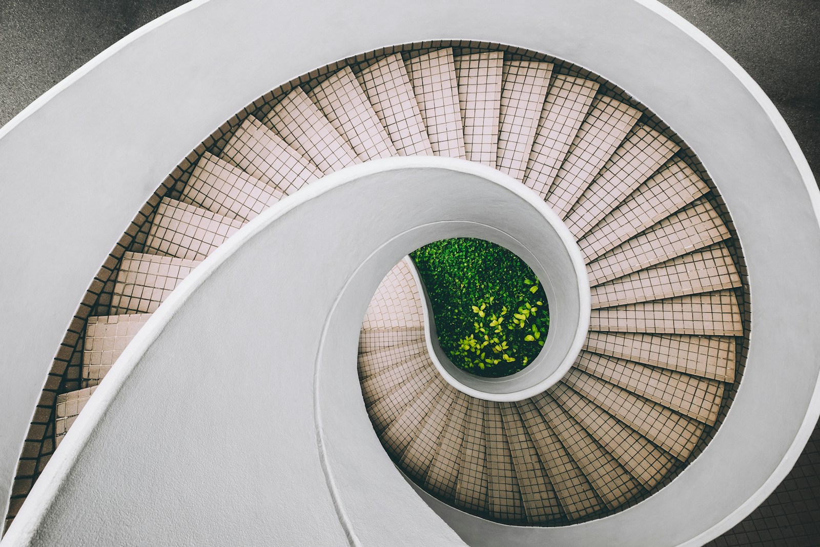 A circular staircase viewed from above around a green central courtyard.