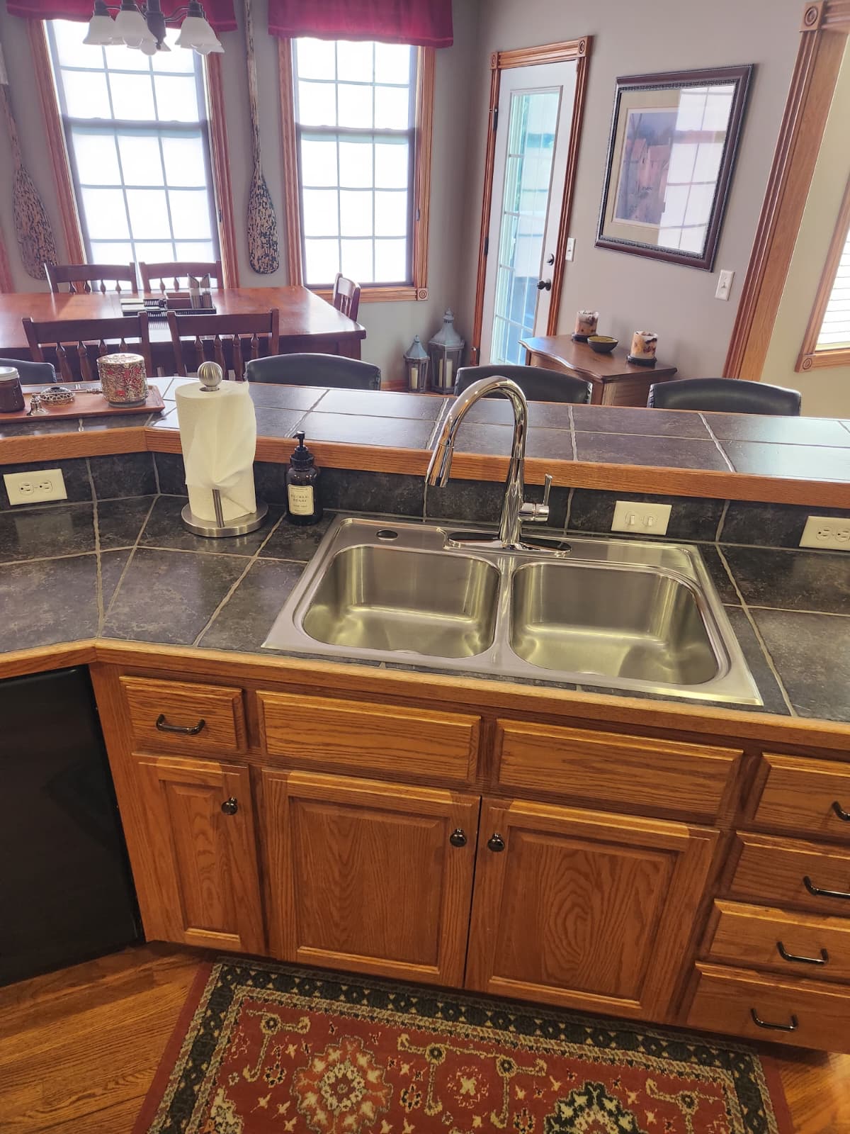Double stainless steel sink and tile counter facing the dining room